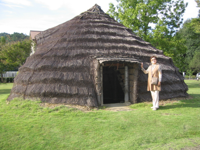 縦穴住居4000年前の自宅前で寛ぐ圭恵子